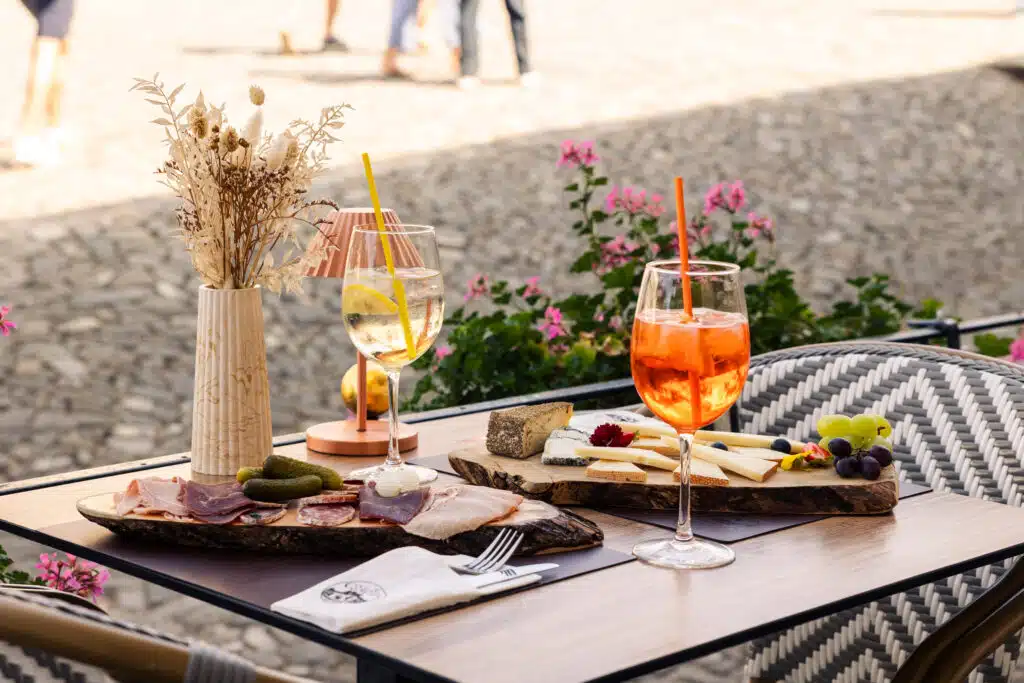 Apéritif sur la terrasse avec planchettes et cocktails au restaurant Le Saint Georges à Gruyères